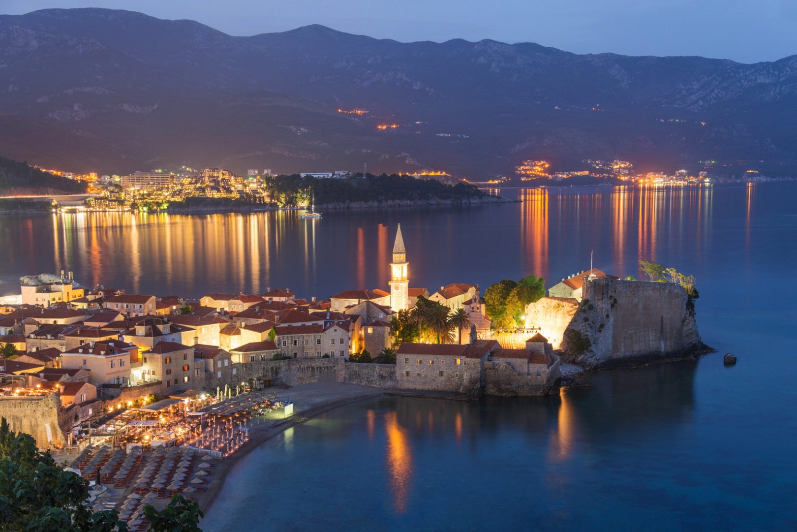 Budva old medieval walled city lights at night. Center of Montenegrin tourism, medieval walled city at Adriatic sea coastline. Montenegro. Europe.