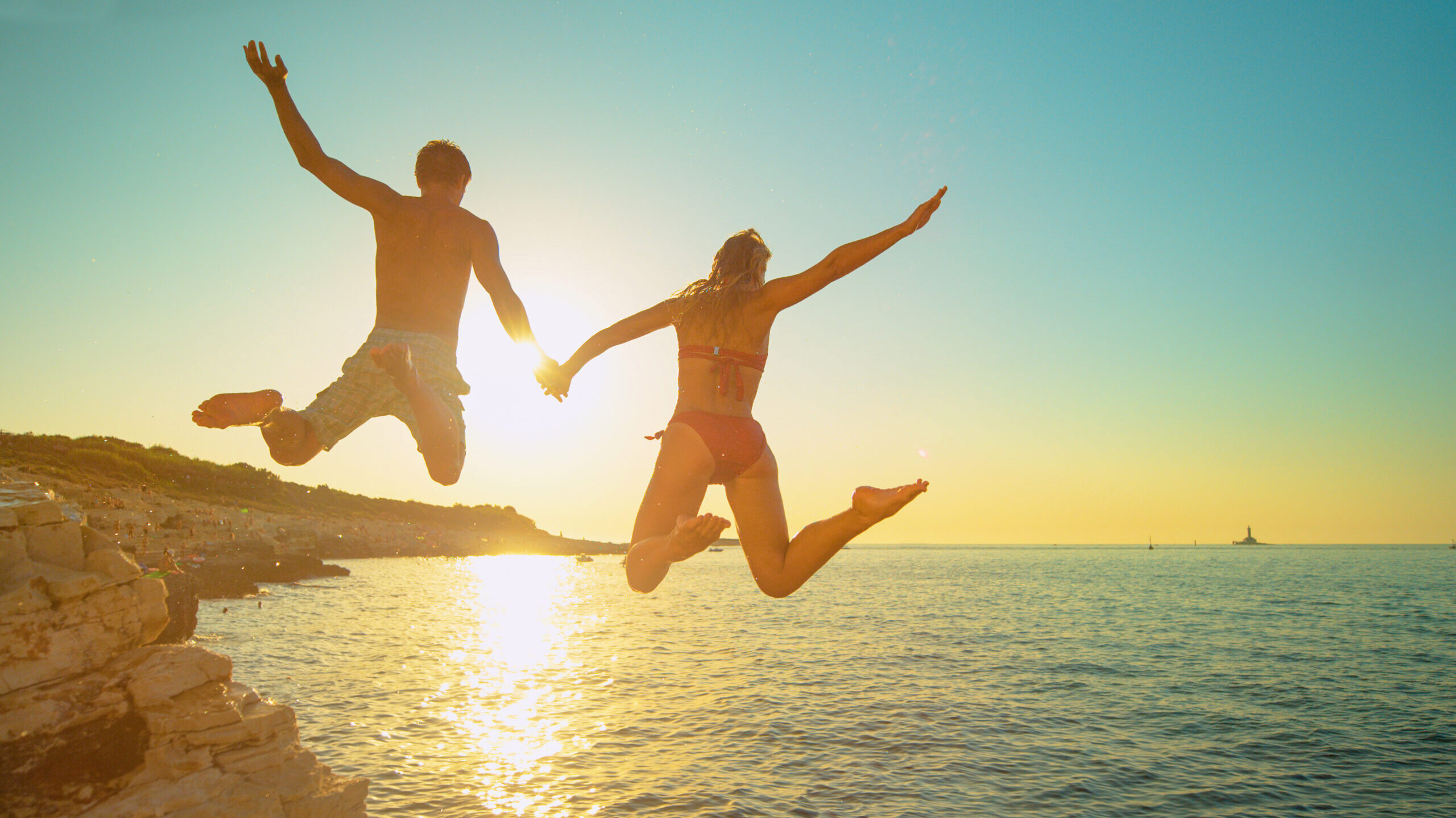 Couple jumping in the sea in Croatia to show the best places to swim in Croatia