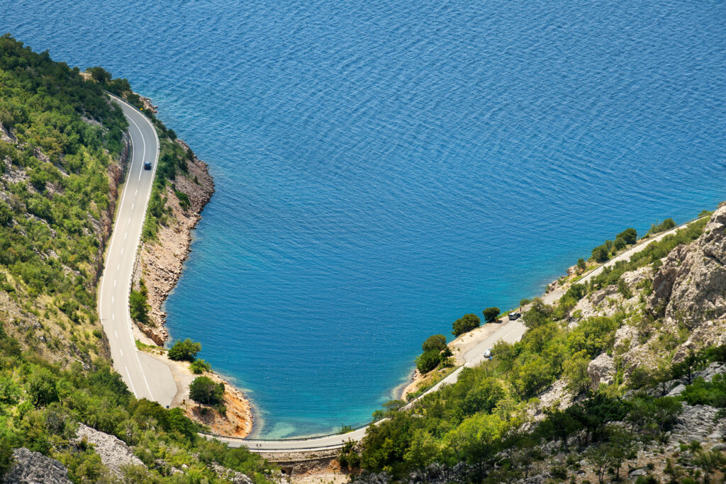 car driving in Croatia on a road next to the ocean