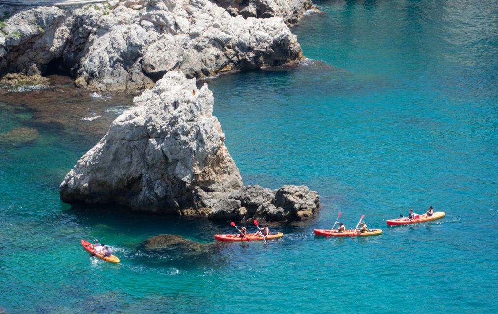 Tour group kayaking near the coastline in Dubrovnik