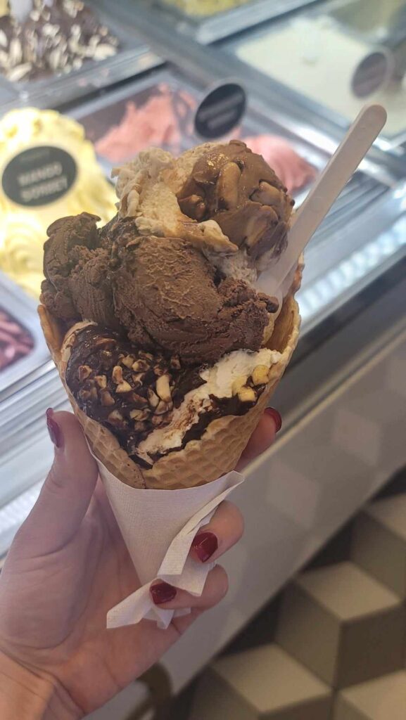 gelato in a cone held up by a hand