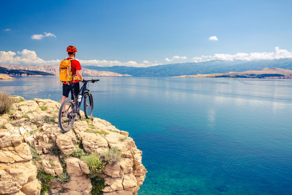 excursions in Croatia - a man cycling and staring out at a lake