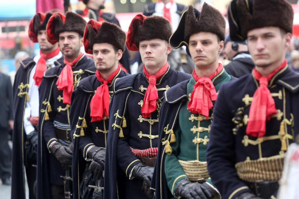 Croatian soldiers in traditional clothing (hats, cravats, uniforms) standing in a line