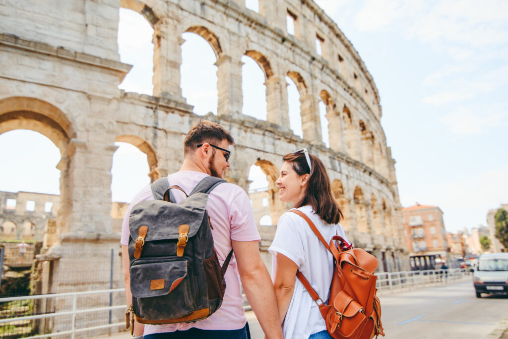 couple looking lovingly into each other's eyes with the Pula Arena in the background