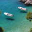 Two small motorboats floating in clear turquoise waters in the best beach town in Croatia