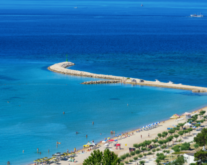 Beach with blue waters and a pier stretching into the distance