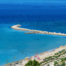 Beach with blue waters and a pier stretching into the distance