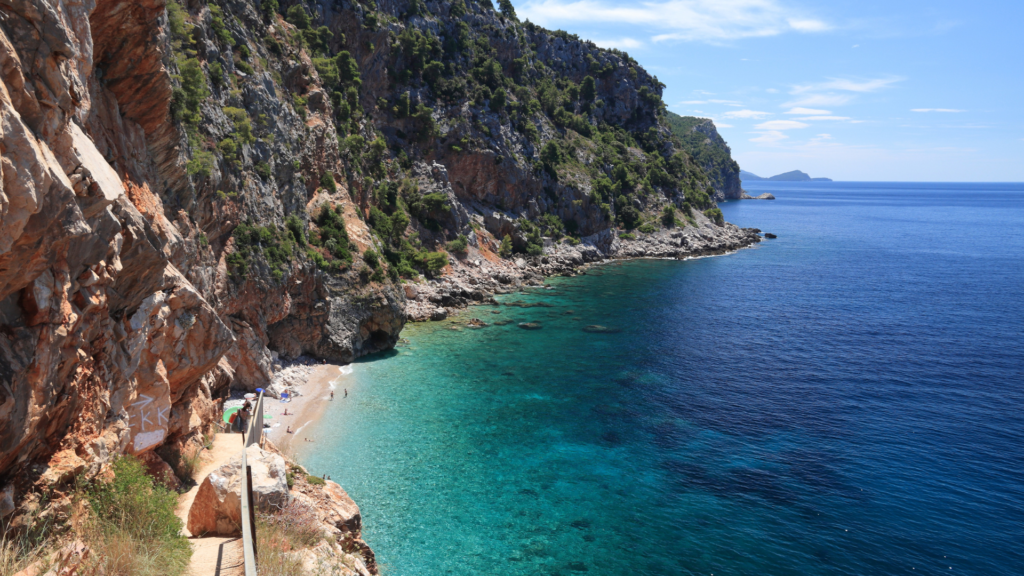 Secluded beach in Croatia, with steep cliffs and clear blue sea